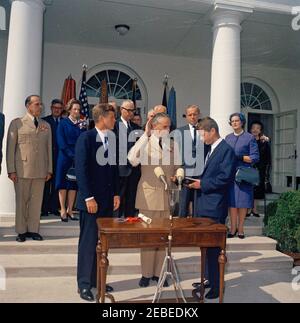 Cérémonie d'assermentation, général Maxwell Taylor, Président, JCS, 12 h 00. Le président John F. Kennedy (au centre à gauche) et d'autres observent que le général Maxwell D. Taylor (avec la main droite relevée et la main gauche sur la Bible) est assermenté en tant que président des chefs d'état-major interarmées (JCS); le procureur général Robert F. Kennedy (au centre à droite de la Bible), administre le serment d'office. À partir des marches de la Colonnade de l'aile ouest (de gauche à droite) : Président sortant du JCS, le général Lyman L. Lemnitzer; Chef d'état-major de la Force aérienne des États-Unis, le général Curtis E. LeMay; Lydia Taylor; l'amiral Arthur W. Radfor Banque D'Images
