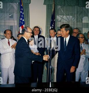 Cérémonie d'assermentation, deLesseps S. Morrison, Sr., représentant des États-Unis auprès de l'Organisation des États américains (OEA), et Robert Woodward, secrétaire d'État adjoint aux Affaires interaméricaines, 11 h 05. Cérémonies d'assermentation pour les deLesseps S. Morrison en tant qu'ambassadeur des États-Unis auprès de l'Organisation des États américains (OEA) et Robert F. Woodward en tant que secrétaire d'État adjoint aux affaires interaméricaines. Robert Woodward, entre la main avec le président John F. Kennedy; deLesseps Morrison (à gauche, portant un costume blanc et une cravate rouge); John Randolph u0022Randyu0022 Morrison (détenu par un homme non identifié); o Banque D'Images