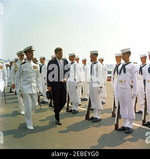 Allocution de commencement à la US Naval Academy, Annapolis, Maryland, 11:04AM. Le président John F. Kennedy en route pour la cérémonie de remise en fonction à l'Académie navale des États-Unis, Annapolis, Maryland. La photographie inclut également l'aide navale au Président Tazewell T. Shepard et la Garde d'honneur de la Marine des États-Unis.