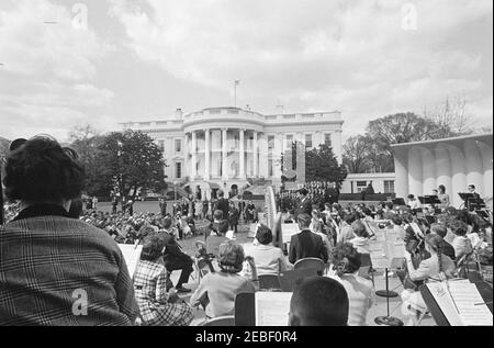Programme musical pour les jeunes de la première Dame Jacqueline Kennedyu0027s (JBK), 14 h 35. Le président John F. Kennedy (au centre à gauche, de retour à la caméra) fait des remarques au cours de la troisième série de programmes musicaux pour les jeunes par les jeunes de la première dame Jacqueline Kennedyu0027s. Le chef du Greater Boston Youth Symphony Orchestra (GBYSO), le Dr Marvin Rabin (au centre à droite), est sur scène avec l'orchestre derrière le Président Kennedy; les membres du Breckenridge Boys Choir se tiennent en formation à gauche de la scène. South Lawn, Maison Blanche, Washington, D.C. Banque D'Images