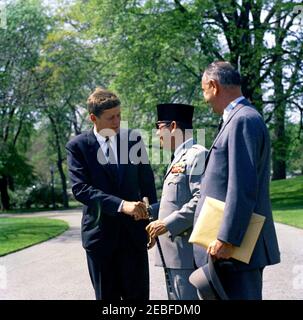 Cérémonies de départ pour Sukarno, Président de l'Indonésie, 10:40. Le Président John F. Kennedy tremble la main avec le Président de l'Indonésie Ahmed Sukarno avant le départ du Président Sukarnou2019s, South Lawn, White House, Washington, D.C. le Vice-Président Lyndon B. Johnson regarde. Banque D'Images