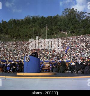 Voyage en Californie : cérémonie d'anniversaire de la Charte, Université de Californie à Berkeley, 13:40. Le président John F. Kennedy parle après avoir reçu un doctorat honorifique en droit de l'Université de Californie, qui lui a été remis par le président de l'Université de Californie, M. Clark Kerr, lors de la 94e cérémonie de la Charte de l'Université de Californie. Assis à droite du lutrin (G-D): Dr Kerr; chancelier nouvellement inauguré de l'Université de Californie à Berkeley, Edward W. Strong; ancien président de l'Université de Californie, Dr Robert Gordon Sproul (derrière le poste de microphone); autres non identifies Banque D'Images