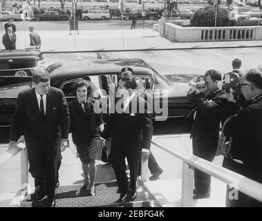 Adresse au Pan American Union Building, 10:53AM. Le Président John F. Kennedy; la première Dame Jacqueline Kennedy; et le Secrétaire général de l'Union panaméricaine Dr. Josu00e9 Mora entrent dans l'édifice de l'Union panaméricaine à Washington, D.C., où le Président fera une allocution à la session protocolaire du Conseil de l'Organisation des États américains. Les photographes de presse observent. Banque D'Images