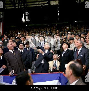 Jour d'ouverture de la saison de baseball 1961, 13:10. Le président John F. Kennedy lance le premier terrain de la saison de baseball 1961 au Griffith Stadium, Washington, D.C., parmi les participants, mentionnons le vice-président Lyndon B. Johnson; le sénateur Hubert Humphrey, du Minnesota; l'adjoint spécial du président Dave Powers; Propriétaire majoritaire de la franchise des sénateurs de Washington, le général Elwood R. u201cPeteu201d Quesada; le chef de la minorité du Sénat Everett Dirksen de l'Illinois; le secrétaire à la Santé, à l'éducation et au bien-être social Abraham Ribicoff; le secrétaire associé à la presse Andrew Hatcher; les agents des services secrets Gerald u0022Jerr Banque D'Images