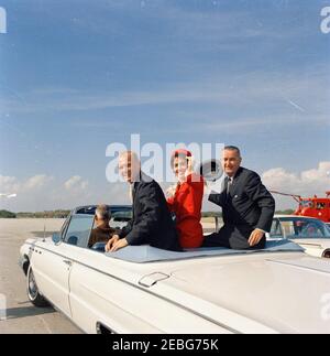Remise de la Médaille du service distingué (DSM) de la NASA à l'astronaute John Herschel Glenn, Jr., à Cape Canaveral. Le lieutenant-colonel John H. Glenn, Jr. (À gauche), son épouse Annie Glenn, Et le vice-président Lyndon B. Johnson (à droite) s'assoient à l'arrière d'un cabriolet alors que leur cortège quitte la base aérienne de Patrick en route vers la station aérienne de Cape Canaveral pour la cérémonie de remise de la Médaille du service distingué de la National Aeronautics and Space Administration (NASA) au lieutenant-colonel Glenn. Comté de Brevard, Floride. Banque D'Images