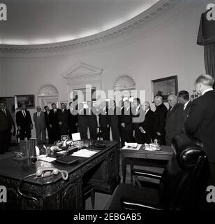 Cérémonie d'assermentation, Comité consultatif général de l'Agence pour le contrôle des armements et le désarmement, 12 h 18. Le Président John F. Kennedy (au centre à gauche, avec les armes levées) et d'autres assistent à la cérémonie d'assermentation des membres du Comité consultatif général de l'Office du contrôle des armements et du désarmement. (G-D) Greffier exécutif adjoint de la Maison Blanche Herbert L. Miller, Directeur de l'Agence de contrôle des armements et du désarmement (ACDA) William C. Foster, Président de la Fédération américaine du travail et du Congrès des organisations industrielles (AFL-CIO) George Meany, Dean A. McGee, ancien Secrétaire adjoint de la Banque D'Images