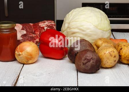 Un ensemble de produits pour faire une délicieuse soupe connue sous le nom de borsch ukrainien. Poitrine de bœuf, chou blanc, pommes de terre, betteraves, carottes, poivrons et tomates Banque D'Images