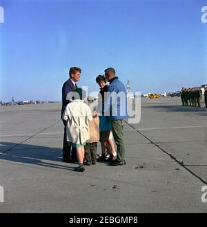 Visite de la flotte de l'Atlantique : le président Kennedy voit les exercices du corps marin à Bogue Field et à Onslow Beach, Camp Lejeune, Caroline du Nord, 14:11. Le président John F. Kennedy (à gauche) s'entretient avec un officier et une famille non identifiés du corps des Marines des États-Unis avant son départ de Caroline du Nord, à la suite d'une visite à la flotte de l'Atlantique des États-Unis. Marine corps Air Station Cherry point, Caroline du Nord. Banque D'Images