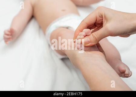 La mère fait un massage des pieds de son petit bébé. Maman et son enfant. Concept de soins de santé pour enfant et détente. Banque D'Images