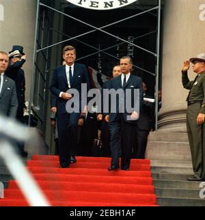 Voyage en Virginie occidentale : discours à l'occasion de la célébration du centenaire de la Virginie occidentale, bâtiment du Capitole de l'État, Charleston, 11:30. Le président John F. Kennedy et le gouverneur de la Virginie-Occidentale, William W. Barron (à droite), quittent le bâtiment du Capitole de l'État à Charleston, en Virginie-Occidentale; le président a visité le bâtiment du Capitole pour assister à une célébration commémorant le centenaire du statut2019s. Le sénateur Jennings Randolph (Virginie-Occidentale) marche derrière le gouverneur; l'agent du Service secret de la Maison Blanche, Frank Yeager, se trouve tout à gauche. [Photo de Harold Sellers] Banque D'Images