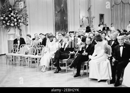 Dîner en l'honneur d'Andru00e9 Malraux, ministre d'État aux Affaires culturelles de France, 8 h 00. Le Président John F. Kennedy et d'autres se réunissent dans la salle est pour assister à un spectacle musical lors d'un dîner en l'honneur du Ministre d'État aux Affaires culturelles de France, Andru00e9 Malraux. Le président Kennedy (au centre à gauche) visite la femme de la ministre, la pianiste Madeleine Malraux; la première dame Jacqueline Kennedy (à droite) visite la ministre Malraux. L'ambassadeur de France aux États-Unis, Hervu00e9 Alphand, siège en première ligne (à l'extrême droite). Également en photo : Directeur du Service des parcs nationaux (SNP), Banque D'Images