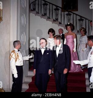 Dîner en l'honneur d'Andru00e9 Malraux, ministre d'État aux Affaires culturelles de France, 8 h 00. Le président John F. Kennedy et le ministre d'État aux Affaires culturelles de France, Andru00e9 Malraux (à gauche, premier plan), arrivent à un dîner en l'honneur du ministre Malraux. À l'arrière (G-D) : épouse de la ministre, pianiste Madeleine Malraux; ambassadeur de France aux États-Unis, Hervu00e9 Alphand; première dame Jacqueline Kennedy; épouse de l'ambassadeur, Nicole Alphand; aide navale au président, capitaine Tazewell Shepard (à la limite du cadre). Deux aides sociales non identifiées bordent l'escalier. Grand escalier Banque D'Images