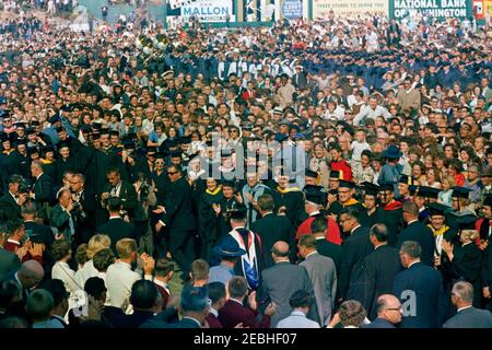 Visite de conservation des États de l'Ouest: Washington, Tacoma: Le Président Kennedy donne son discours au stade Cheney. Le président John F. Kennedy (en bas à droite) et d'autres personnes traversent une foule de gens, y compris des membres du corps professoral, réunis au stade Cheney à Tacoma, Washington, lors d'une cérémonie de convocation conjointe organisée par l'Université luthérienne du Pacifique et l'Université de Puget Sound. Également en photo : le président de l'Université de Puget Sound, le Dr R. Franklin Thompson; le président de l'Université luthérienne du Pacifique, le Dr Robert A. L. Mortvedt; le sénateur Warren G. Magnuson (Washington); le gouverneur de Washington, al Banque D'Images