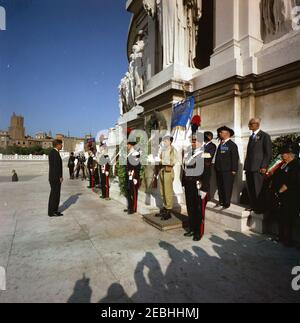 Voyage en Europe: Italie, Rome: Le Président Kennedy à la tombe du Soldat inconnu. Le Président John F. Kennedy observe un moment de silence devant la tombe du Soldat inconnu au monument Victor Emmanuel (u201cMonumento Nazionale a Vittorio Emanuele IIu201d) à Rome, en Italie; une couronne a été déposée sur la tombe au nom du Presidentu2019s. Des membres de la police militaire italienne (Carabinieri) se tiennent de chaque côté de la couronne. Banque D'Images