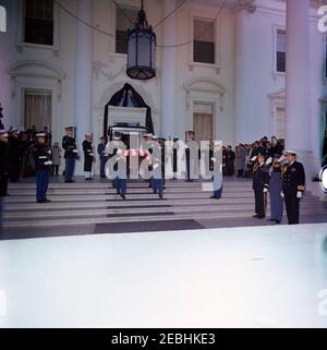 Funérailles d'État du président Kennedy : départ de la Maison Blanche et procession au Capitole des États-Unis. Les pallbearers de la garde d'honneur portent le cercueil à pavillon du président John F. Kennedy de la Maison Blanche, avant une procession funéraire au Capitole. Jacqueline Kennedy et d'autres membres de la famille Kennedy marchent derrière le cercueil. Debout à droite (salut) : aide militaire au président Kennedy, le général Chester V. Clifton; aide aérienne au président Kennedy, le général de brigade Godfrey T. McHugh; aide navale au président Kennedy, le capitaine Tazewell Shepard. Membres des pres Banque D'Images