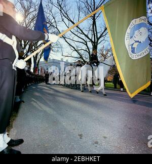 Funérailles d'État du président Kennedy : départ de la Maison Blanche et procession au Capitole des États-Unis. Le cortège funèbre du président John F. Kennedy part de la Maison Blanche pour le bâtiment du Capitole; les membres de la Garde de couleur bordent l'allée de la pelouse nord. White House, Washington, D.C. Banque D'Images