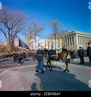 Funérailles d'État du président Kennedy : départ de la Maison Blanche et procession au Capitole des États-Unis. Le cheval Riderless, Black Jack (dirigé par le soldat Arthur A. Carlson de première classe), marche dans le cortège funèbre du président John F. Kennedy alors qu'il tourne sur Pennsylvania Avenue, en route de la Maison Blanche au Capitole. Washington, D.C. Banque D'Images