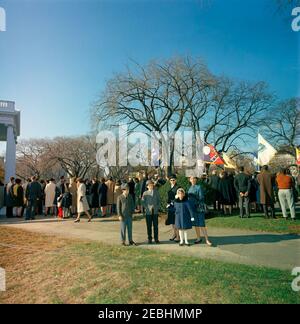 Funérailles d'État du président Kennedy : départ de la Maison Blanche et procession au Capitole des États-Unis. Les amateurs de deuil se rassemblent à l'allée North Lawn de la Maison Blanche pour assister à la procession funèbre du président John F. Kennedy au Capitole; une famille non identifiée se trouve au centre. Washington, D.C. Banque D'Images