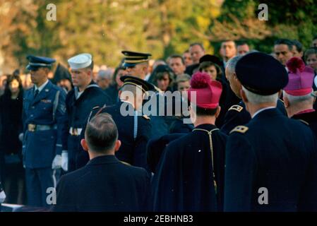 Funérailles d'État du président Kennedy : messe Requiem à la cathédrale Saint-Matthieu 2019s et enterrement au cimetière national d'Arlington. Des membres de la famille Kennedy et d'autres assistent aux funérailles d'État du président John F. Kennedy; Jacqueline Kennedy (pour la plupart cachée) allume la flamme éternelle. Également en photo : Patricia Kennedy Lawford; Jean Kennedy Smith; Eunice Kennedy Shriver; Joseph P. Kennedy, II; directeur du corps de la paix, R. Sargent Shriver; ami de la famille Kennedy, Kirk LeMoyne u201cLemu201d Billings; agent du service secret de la Maison Blanche, Clint Hill. Les pallers de garde d'honneur se tiennent à Banque D'Images