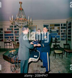 Funérailles d'État du président Kennedy: Des membres du 3e Régiment d'infanterie des États-Unis (la vieille garde) présentent la caparison noire Jacku2019s (selle, bride, couverture, épée, bottes et éperons) à l'aide militaire adjointe, le lieutenant-colonel James M. Connell. Les membres de la vieille garde livrent à la Maison Blanche la selle, la bride, la couverture, l'épée, les bottes et les éperons de u0022Black Jack,u0022 le cheval sans riderless de la procession funéraire du président John F. Kennedy. L'Adjudant-chef John C. McKinney (à droite), du 3e Régiment d'infanterie des États-Unis (la vieille garde), remet un article à l'aide militaire adjointe, le Lieutenant Co Banque D'Images