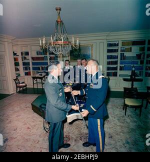 Funérailles d'État du président Kennedy: Des membres du 3e Régiment d'infanterie des États-Unis (la vieille garde) présentent la caparison noire Jacku2019s (selle, bride, couverture, épée, bottes et éperons) à l'aide militaire adjointe, le lieutenant-colonel James M. Connell. Les membres du 3e Régiment d'infanterie des États-Unis (la vieille garde) livrent à la Maison Blanche la selle, la bride, la couverture, l'épée, les bottes et les éperons de u0022Black Jack,u0022 le cheval sans rebord de la procession funéraire du président John F. Kennedy. En premier plan, le capitaine Richard C. Cloy (à droite) présente une épée à l'aide militaire adjointe, le lieutenant-colonel James M. C Banque D'Images