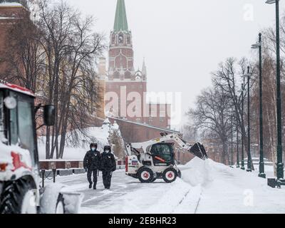 Moscou. Russie. 12 février 2021. Un petit bobcat de pelle-chargeuse enlève la neige du trottoir près des murs du Kremlin lors d'une forte chute de neige Banque D'Images