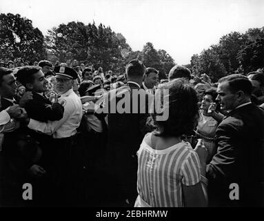 Visite des étudiants du service après-vente américain, 10:00. Le président John F. Kennedy (au centre-droit, pour la plupart caché) accueille les étudiants de l'American Field Service (AFS) sur la pelouse sud de la Maison Blanche, Washington, D.C. les agents de la police de la Maison Blanche tiennent la foule à gauche. Également en photo : les agents du service secret de la Maison Blanche, Gerald A. u0022Jerryu0022 Behn, Emory Roberts et Walt Coughlin. Banque D'Images