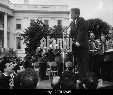 Réception pour étudiants étrangers, 3:55. Le Président John F. Kennedy (au lectern) prononce des remarques lors d'une réception pour des étudiants étrangers sur la pelouse sud de la Maison Blanche, Washington, D.C. les invités comprennent des étudiants des institutions suivantes de la région de Washington, D.C. : Université américaine, Université catholique d'Amérique, Collège Gallaudet, Université George Washington, Université Georgetown, Université Howard, École d'études internationales avancées de l'Université Johns Hopkins, Trinity College (Washington, D.C.), Université du Maryland et Collège Dunbarton de Sainte Croix. Membres de Banque D'Images