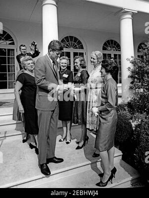 Visite des membres de la u0022Ninety-Nines,u0022 une association de pilotes féminins, 9:45. Le président John F. Kennedy visite des membres de l'Organisation internationale des femmes pilotes Ninety-Nines, Inc., au sujet de l'émission d'un timbre commémoratif Amelia Earhart. De gauche à droite : ancienne présidente internationale, Blanche Noyes; présidente internationale, Louise M. Smith (pour la plupart cachée derrière Mme Noyes); photographe non identifié (debout en colonnade); président Kennedy; Alice Hammond; Marion Andrews-Lopez; Fay Gillis Wells; non identifié. Agent du service secret de la Maison Blanche, Ken Giannoules, St Banque D'Images