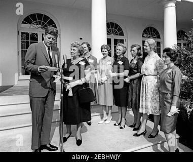 Visite des membres de la u0022Ninety-Nines,u0022 une association de pilotes féminins, 9:45. Le président John F. Kennedy fait des remarques aux membres de la Ninety-Nines, Inc., Organisation internationale des femmes pilotes, au cours d'une visite au sujet de l'émission d'un timbre commémoratif Amelia Earhart. De gauche à droite : président Kennedy; ancien président international, Blanche Noyes; président international, Louise M. Smith; Virginia Thompson; Alice Hammond; Marion Andrews-Lopez; Fay Gillis Wells; non identifié. Rose Garden, Maison Blanche, Washington, D.C. Banque D'Images