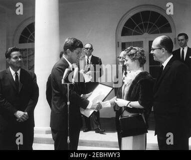 Remise du Prix national de l'enseignant de l'année à Marjorie L. French de Topeka, Kansas, 11 h 55. Le président John F. Kennedy tremble la main avec Marjorie L. French, de Topeka, Kansas, lorsqu'il lui remet le Prix national de l'enseignant de l'année (parrainé par le Conseil des directeurs d'école en chef de l'État, le Bureau de l'éducation des États-Unis et LOOK Magazine). De gauche à droite : le commissaire à l'éducation, M. Sterling M. McMurrin; le président Kennedy; l'adjoint spécial du président, Dave Powers (en arrière-plan); le mari de Mme Frenchu2019s, Freeman G. French; Mme French; le secrétaire exécutif du C Banque D'Images