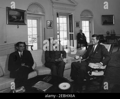 Rencontre avec Sir Alexander Bustamante, premier ministre de la Jamaïque, 10 h 04. Le Président John F. Kennedy (président à bascule) rencontre le Premier Ministre de la Jamaïque, Sir Alexander Bustamante, et le Ministre des finances de la Jamaïque, Donald B. Sangster (à l'extrême gauche). Le chef adjoint du Protocole, William J. Tonesk, est assis en arrière-plan. Oval Office, Maison Blanche, Washington, D.C. Banque D'Images