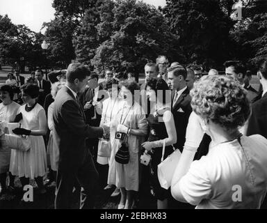 Visite de la classe Senior de Glen Lake (Michigan) High School, 9:50. Le président John F. Kennedy tremble la main avec un membre de la classe senior de Glen Lake High School (Maple City, Michigan) sur la pelouse de l'aile ouest de la Maison Blanche. Le secrétaire de presse adjoint, Malcolm Kilduff, Jr., est également en photo. Tous les autres sont non identifiés. Washington, D.C. [Veuillez consulter les dossiers du personnel de la Maison-Blanche de John J. McNally, série 7. Photographies, 1961-1963, pour une liste complète de la classe senior.] Banque D'Images