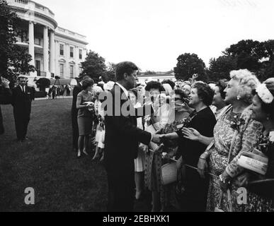 Visite des participants à la Conférence de campagne 1962 pour les femmes démocratiques, 9 h 35. Le président John F. Kennedy accueille les participants à la Conférence de campagne 1962 pour les femmes démocratiques; la première dame Jacqueline Kennedy et la vice-présidente Lyndon B. Johnson (pour la plupart cachée) accueillent les visiteurs à gauche. Également en photo : agent du service secret de la Maison Blanche, Clint Hill. South Lawn, White House, Washington, D.C. [l'encre fond le long du bord supérieur droit de l'impression de fichier.] Banque D'Images