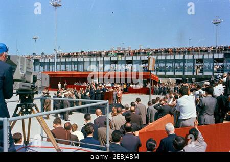 Voyage en Europe: Italie, Rome: Arrivée à l'aéroport de Fiumicino, et présentation d'un cadeau par le Président Antonio Segni au Palais Quirinale. Le président John F. Kennedy (au lectern) prononce des remarques à l'intention d'une grande foule rassemblée à l'aéroport de Fiumicino à son arrivée à Rome, en Italie. Banque D'Images