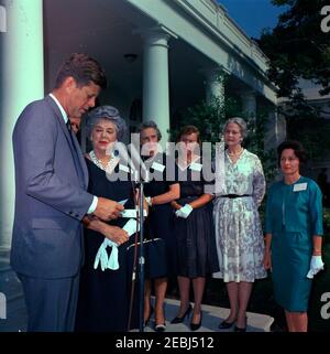 Visite des membres de la u0022Ninety-Nines,u0022 une association de pilotes féminins, 9:45. Le président John F. Kennedy fait des remarques aux membres de la Ninety-Nines, Inc., Organisation internationale des femmes pilotes, au cours d'une visite au sujet de l'émission d'un timbre commémoratif Amelia Earhart. De gauche à droite: Président Kennedy; président international, Louise M. Smith (pour la plupart cachée); ancien président international, Blanche Noyes; Alice Hammond; Marion Andrews-Lopez; Fay Gillis Wells; non identifié. Rose Garden, Maison Blanche, Washington, D.C. Banque D'Images