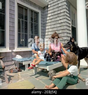 Voyage à Hyannis Port u2013 Squaw Island, 1963-08-14. Le président John F. Kennedy, la première dame Jacqueline Kennedy, et leurs enfants, Caroline Kennedy et John F. Kennedy, Jr., s'assoient avec leurs chiens, Shannon, Wolf, White Tips, Blackie, et Clipper, à la maison Brambletyde sur l'île Squaw, port Hyannis, Massachusetts. Banque D'Images