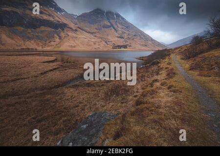 Paysage sombre et isolé du Loch Achtriochtan à Glencoe, dans les Highlands écossais. Banque D'Images