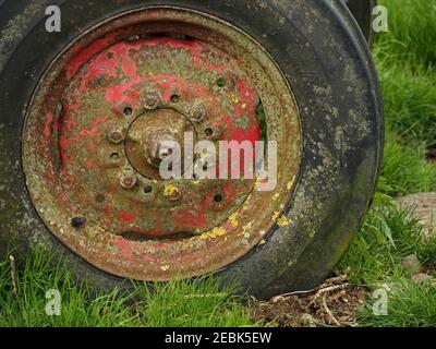 Roue rouge rouillée de l'ancienne remorque de ferme incrustée de lichen jaune Cumbria, Angleterre, Royaume-Uni Banque D'Images