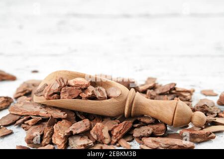 Écorce de pin et pelle en bois rustique sur bois blanc. Banque D'Images