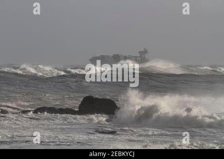 Navire-conteneur traversant la côte portugaise par une journée de tempête Banque D'Images