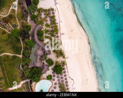 Vue aérienne de parasols de plage toit de chaume de luxe avec vue sur l'océan sur la magnifique côte de sable blanc de l'océan à Nungwi sur l'île de Zanzibar Banque D'Images