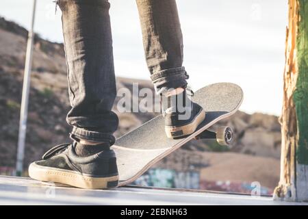 Vue rapprochée d'ados libre de pieds sur une planche à roulettes prêt à commencer une ride sur le half-pipe. À partir patineur sauts et des astuces à la skate park. Let's go en Banque D'Images