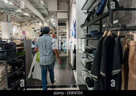 homme debout sur son dos dans un centre commercial achetant des vêtements, avec un sac de shopping dans ses mains. Buenos Aires. Falabella Banque D'Images