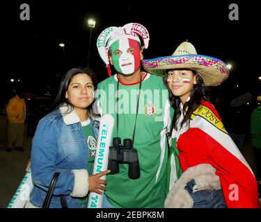 Les mains de football mexicain ont leur visage peint dans le national couleurs Banque D'Images