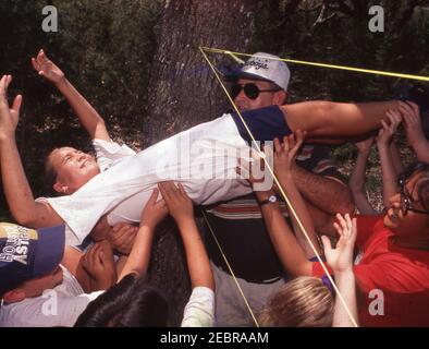 Camp d'éducation de plein air, Bandera, Texas. Les jeunes de 5ème année en voyage de nuit sur le terrain résolvent les problèmes et travaillent en équipe dans le jeu 'Spider Web'. VERSION DU MODÈLE et-172-242 ©Bob Daemmrich Banque D'Images