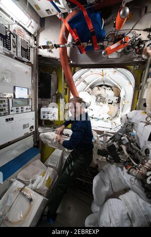 L'astronaute de la NASA et l'ingénieur de vol de l'expédition 64 Shannon Walker inspecte le matériel de sortie de l'espace à l'intérieur de l'aérogare Quest où les sorties de l'espace américain sont entreposées à bord de la Station spatiale internationale le 11 janvier 2021 à Earth Orbit. Banque D'Images