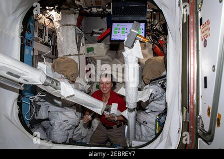 L'astronaute de la NASA et l'ingénieur de vol de l'expédition 64 Shannon Walker inspecte le matériel de sortie de l'espace à l'intérieur de l'écluse Quest où les sorties de l'espace aux États-Unis sont entreposées à bord de la Station spatiale internationale le 30 décembre 2020 à Earth Orbit. Banque D'Images