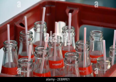 Videz les bouteilles en verre dans une boîte en plastique à l'extérieur d'un restaurant, certaines avec des pailles avant le recyclage. D'une boisson froide de lait de soja en Chine. Banque D'Images