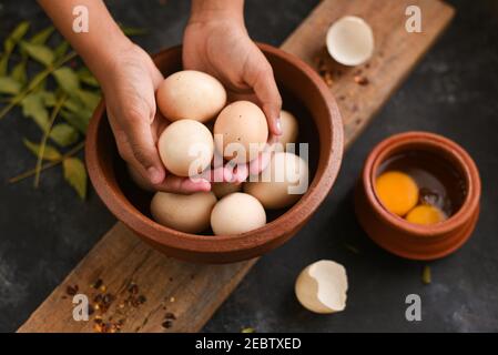 Oeufs de ferme bio crus Kerala Inde. Une fille avec des œufs de poulet dans ses mains. Agriculture de subsistance et concept d'alimentation biologique. Pays frais Banque D'Images